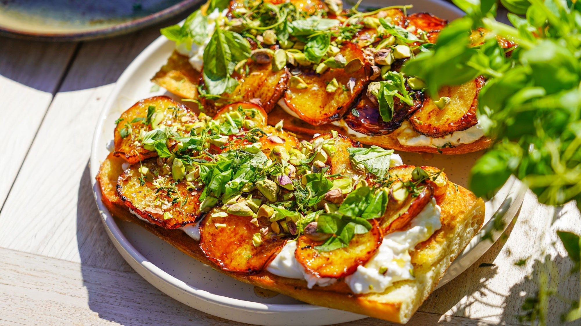 Rostat surdegsbröd med stekt persika, burrata, honung & pistagenötter