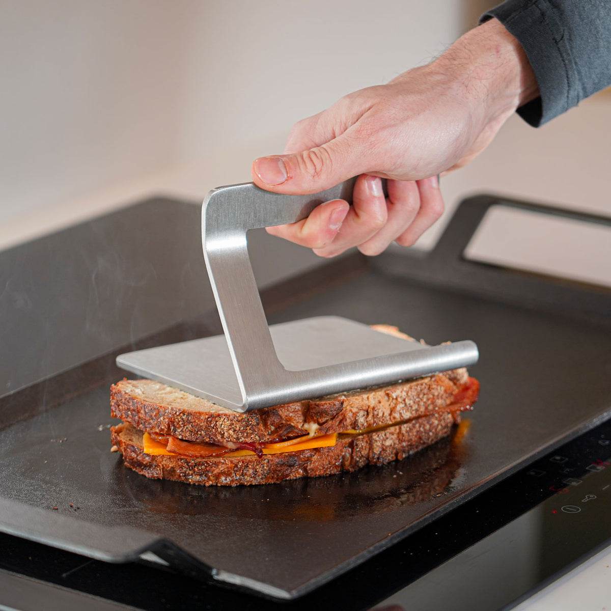 Smasher pressar sandwich på stekhäll