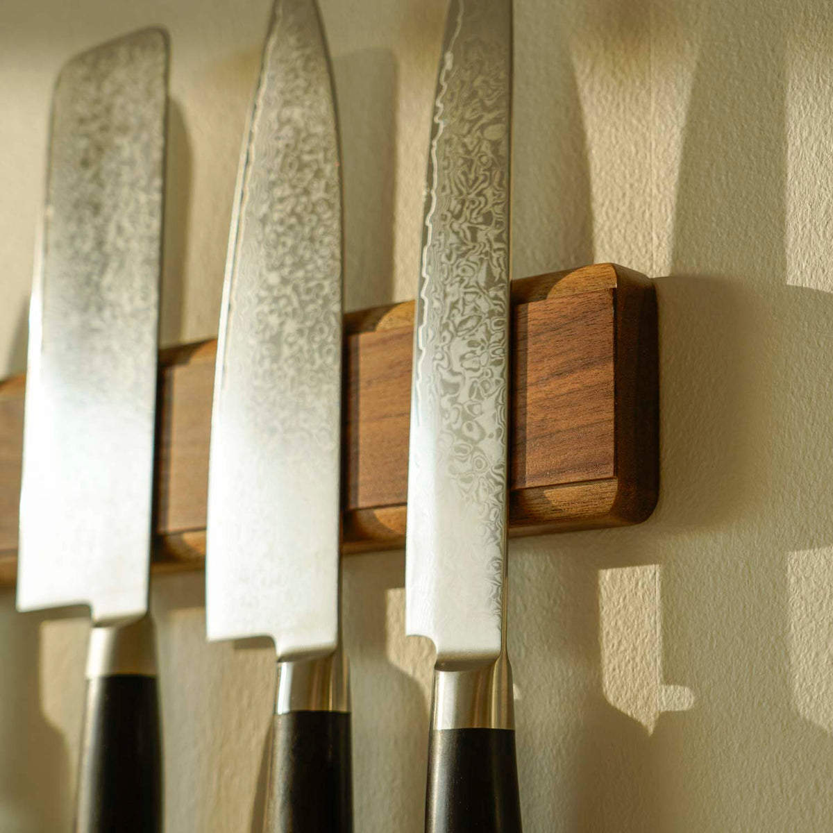Närbild på väggmonterad knivmagnet i valnöt