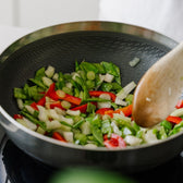 Wok med grönsaker på spisen 